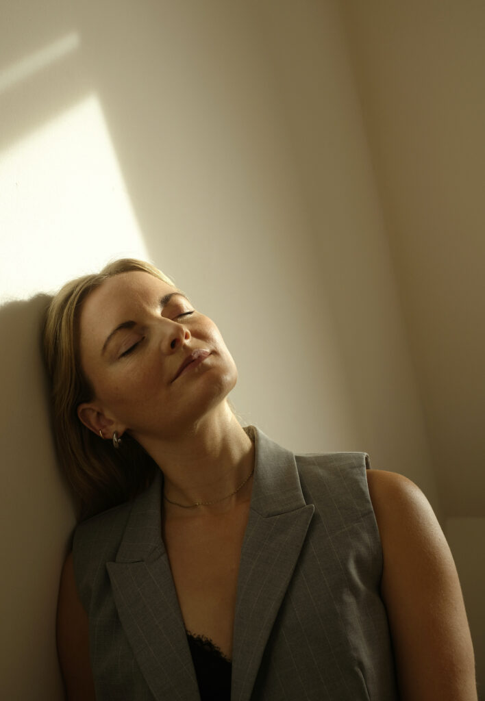 woman leans to the wall, smiling